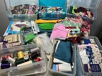 Wide view of multiple bins and containers holding threads, fabrics, and sewing projects stacked