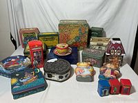 Photo showing entire collection of vintage metal tins with various designs and shapes, including Crayola tins, floral tin, decorative houses, and figurative tins