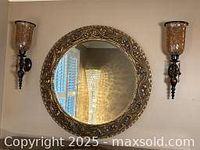 Pair of candle wall sconces mounted on wall with round decorative mirror in middle (mirror sold separately)