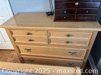 Six drawer wooden dresser, light to medium wood finish, with metal drawer pulls