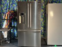 Front exterior view of stainless steel French door refrigerator with dispenser