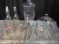 Photo of the entire set showing two glass bottles, the drink urn with spigot, cake plate, and dome lid.