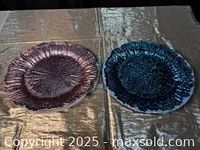 Pair of pink and teal chargers showing scalloped edges and textured pattern under sunlight on table