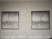 Front view of two abstract prints on canvas with black frames hung side by side on wall.