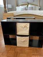 Two brown small storage units with four cubbies each, one unit shown with two beige fabric storage baskets inserted.