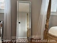Full-length view of standing mirror with decorative bling trim on silver frame.