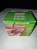 Box of Coleman 4D QuickPump battery-powered air pump showing front and side with product image and description.