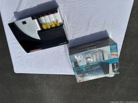 Overview of Emerson automatic coin sorter with coin tubes and original box on white backdrop