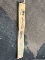 Long narrow cardboard box containing metal bed frame parts with brand, model number, and assembly instructions printed on the side.