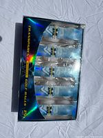 Top view of the box containing 15 transparent golf balls by Michigan with the lid removed showing sealed packaging inside.