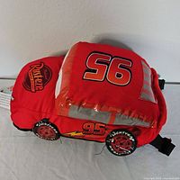 Side view of the red Lightning McQueen plush backpack showing number 95 and Rust-eze logo