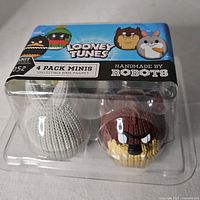 Front view of the sealed 4 pack minis packaging for Looney Tunes collectible vinyl figures, showing two of the four figures inside with knit-style texture.