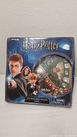 Front of the Harry Potter Triwizard Maze Game box showing characters and game components through window.