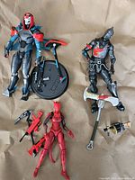 Lot of three Fortnite figures laid on beige background showing all items and accessories.