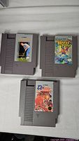 Photo of front side of 3 NES cartridges: Color a Dinosaur, Bary Bill, and Karate Kid themed game.