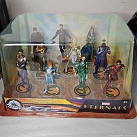 Front view of Marvel Eternals playset with 10 detailed character figures inside clear plastic display packaging against a yellow and blue background.