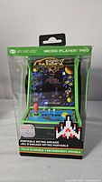 Front view of packaged My Arcade Galaga portable arcade game showing colorful artwork and control panel details.