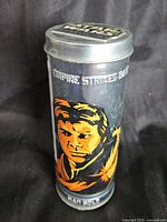 Front view of cylindrical metal tube with Han Solo graphic and The Empire Strikes Back text.