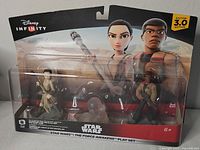 Front view of unopened retail box showing Disney Infinity logo and Star Wars The Force Awakens characters Rey and Finn figures inside plastic window packaging.