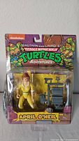 Front view of new in package April O'Neil figure from Teenage Mutant Ninja Turtles Adventures, showing figure and accessory in blister pack.