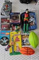 Top-down image showing all toy items laid out including figures, toys, wristwatch, and plush balls.