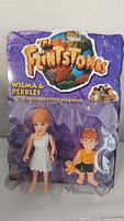 Photo shows original blister pack with Wilma and Pebbles Flintstone figures inside, packaging has The Flintstones logo and character names.