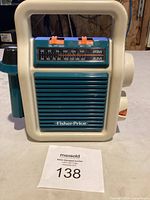 Front view of the vintage 1984 Fisher Price kids radio showing AM/FM dial, speaker grille, and carrying handle.