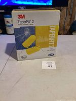 Box of 3M TaperFit 2 ear plugs showing front with yellow ear plug image and branding.