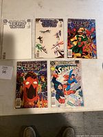 Photo shows five comic books from the Zero Hour series plus a Superboy issue, all laid out on a table.