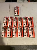 12 DIM Up leggings in their original sealed packaging arranged in rows on a white surface.