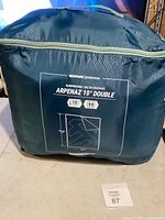 Blue sleeping bag in a blue carrying bag showing brand, model, and temperature rating.