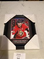 Framed photo with foam corner protectors showing Erik Karlsson in Ottawa Senators red jersey with captain 'C'.
