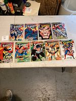 Top view of 10 Superman comic books laid out on a table showing front covers.