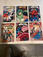Photo showing six Valor comic books arranged on floor, displaying front cover art of each issue.