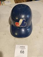 Top view of navy blue Montreal Expos collectible baseball helmet showing Expos logo and scuffed surface.