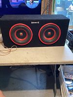 Full front view of the dual Visonik Basson VE subwoofer enclosure showing both speakers and wiring.