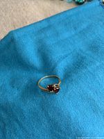 Ring shown on blue fabric surface to highlight design and gemstones