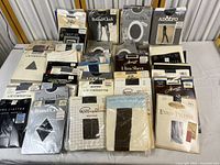 Full spread of assorted pantyhose and control tops from Liz Claiborne, Christian Dior, Round the Clock, L'eggs, Pappagallo, Hanes, Adolfo, and others in original packaging.