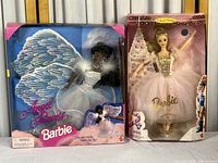 Both Barbie dolls in original packaging showing box wear and damage.