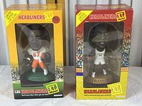 Both sealed collectible figures of Moore and Traylor in original boxed packaging with clear windows.
