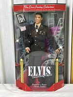 Front view of Elvis Presley Army Years doll in original box showing doll in military uniform, box branding and design.