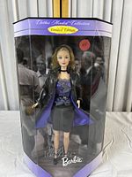 Front view of the boxed Trend Forecaster Barbie doll showing the doll in black leather-look coat with lavender lining and dark grey mini skirt inside original display box with visible wear.