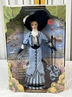 Front view of Barbie doll in box with Victorian-style dress, hat, and parasol; box shows wear.