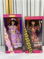 The two dolls in their original boxes, showing front of packaging and dolls standing with cultural-themed backgrounds.