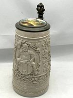Full front view of the salt-glazed beer stein showing relief decoration of Gambrinus and vine leaves.