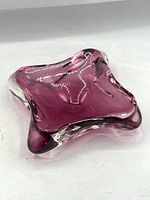 Amethyst purple glass catchall viewed from top, showing organic sculptural shape and thick clear glass outer layer.
