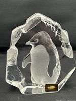 Clear lead crystal paperweight with etched penguin figure and original foil label in front