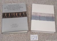 Front covers of both books laid flat side by side on carpet with lot label