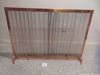 Front view of copper-coloured fire screen with chain-link curtains and copper frame