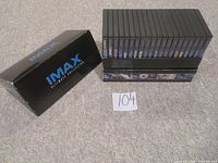 Black IMAX Ultimate Collection box with 20 DVD cases arranged beside it on a carpeted floor, showing spine labels.